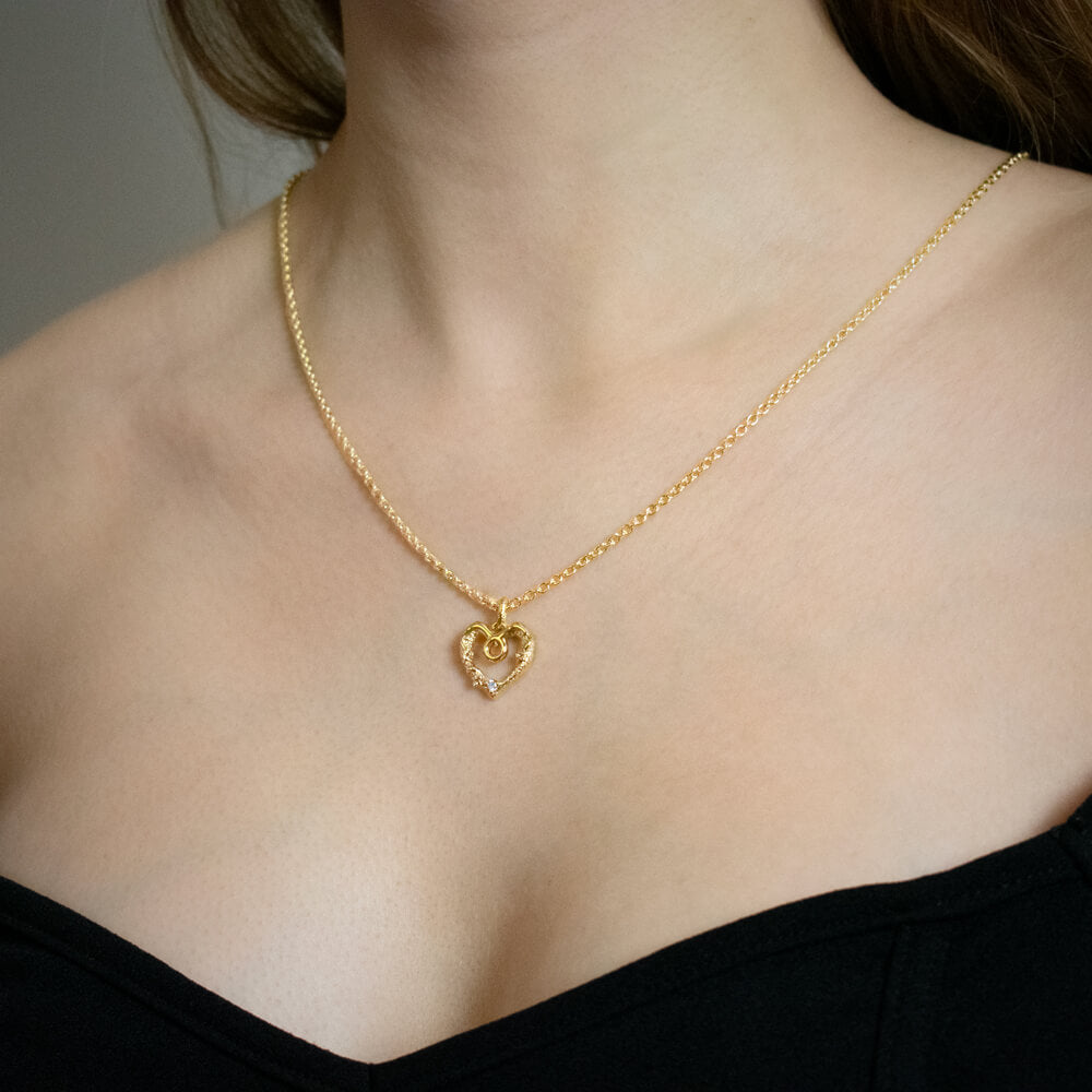 Tyren stjernetegnsvedhæng i 18 kt gult guld med diamant, hjerteformet design, båret på halsen