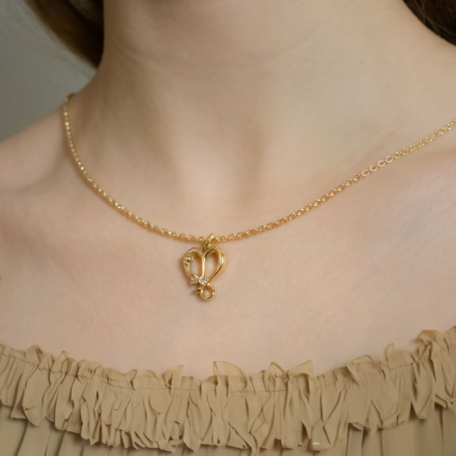 Stenbukken stjernetegnsvedhæng med diamant, hjerteformet design, båret på halsen