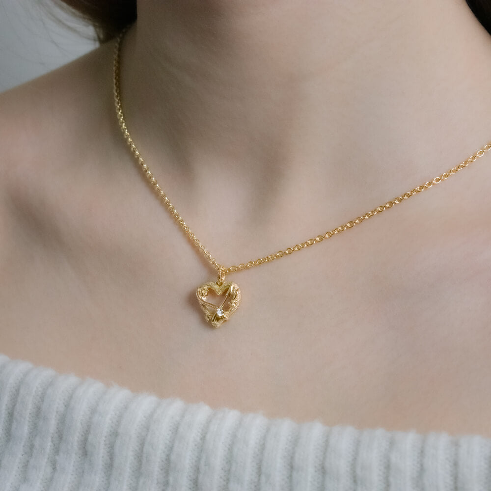 Skytten stjernetegnsvedhæng i 18 kt gult guld med diamant, hjerteformet design, båret på halsen