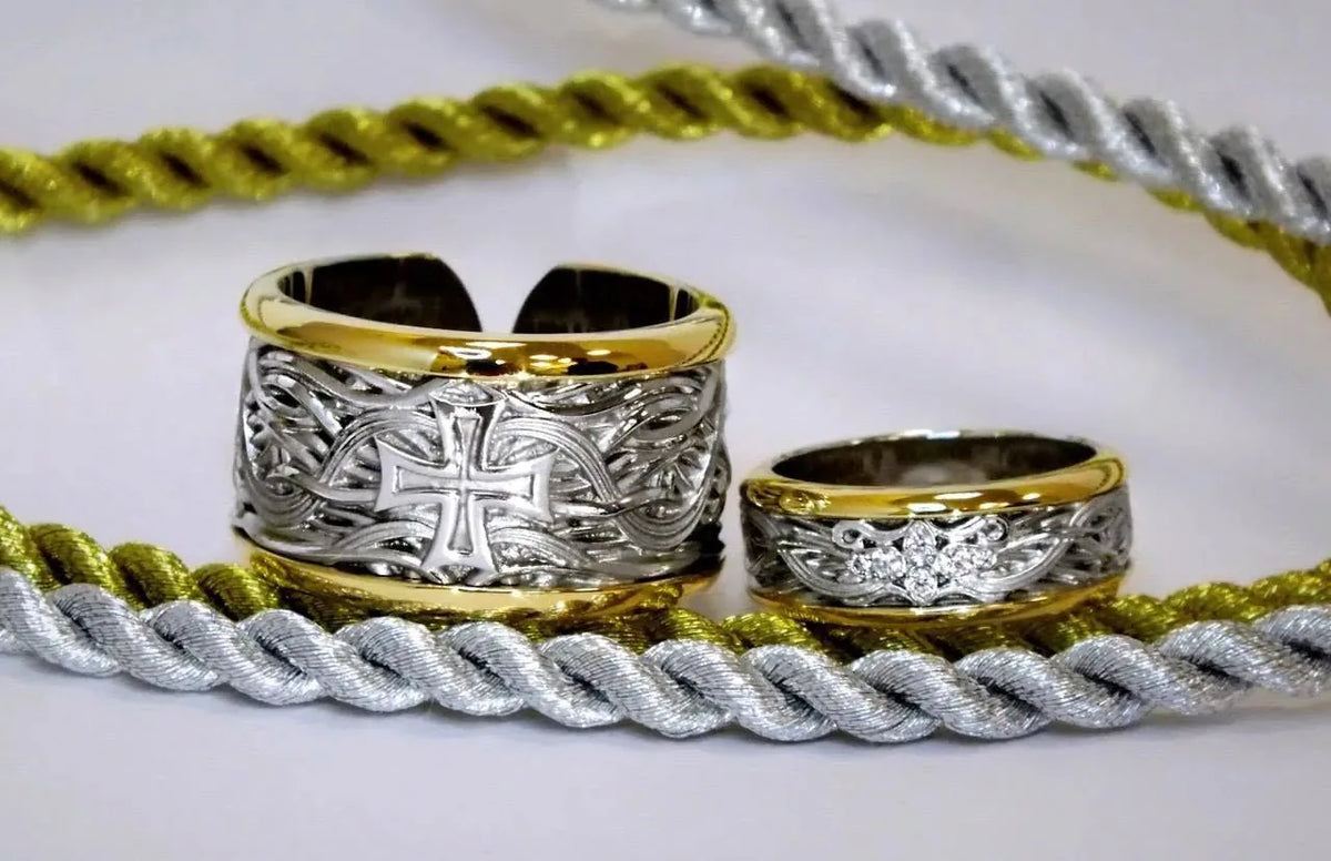 Brede åbne vielsesringe med midterflade i hvidguld, kanter i gult guld, personlige symboler og diamanter i hendes ring