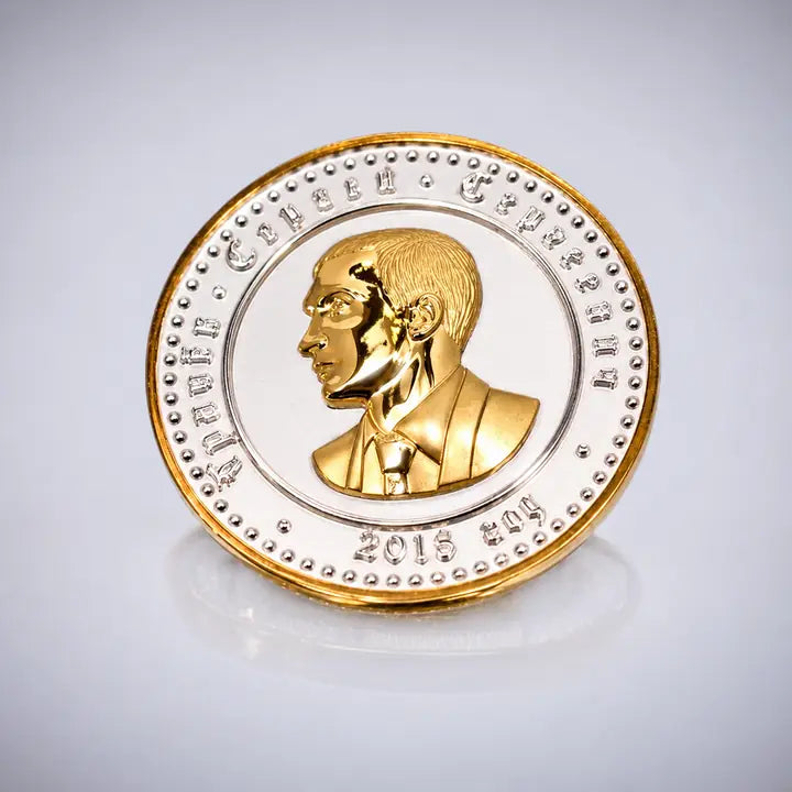 Personlig fødselsdagsmønt i sølv med indsatser af 18 karat guld, portræt på den ene side og våbenskjold på den anden.