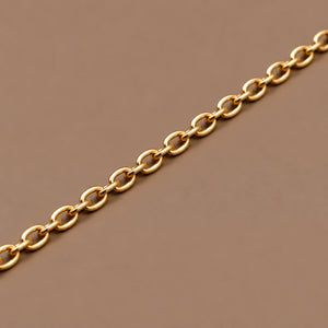 Ankerkæde i 18 kt gult guld, 2 mm, med ovale led på taupe baggrund.