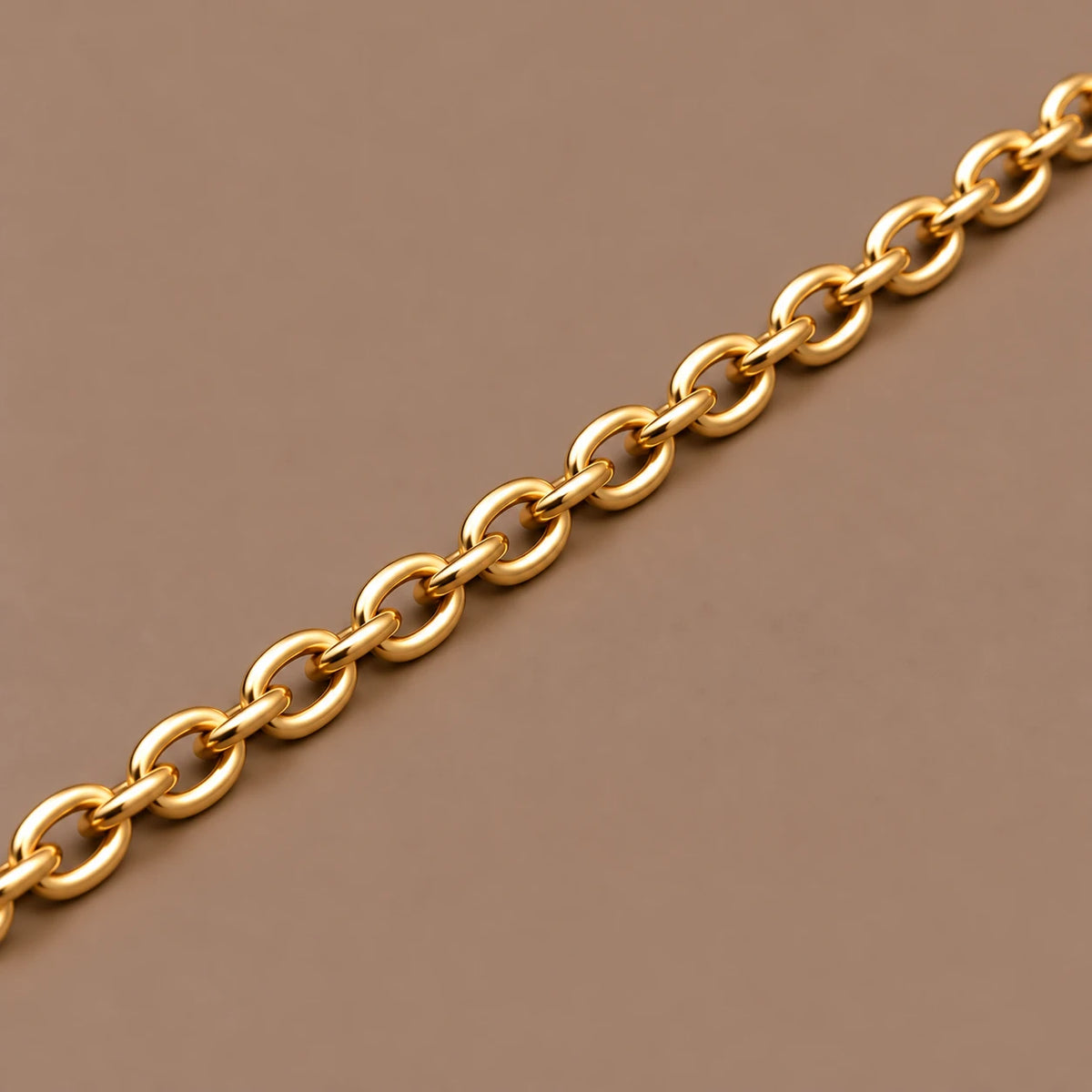 Ankerkæde i 18 kt gult guld, 3 mm, med ovale led på taupe baggrund.