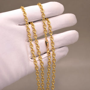 Ankerkæde i 18 kt gult guld, 4,2 mm, på hvid handske med blå diamant ved låsen.