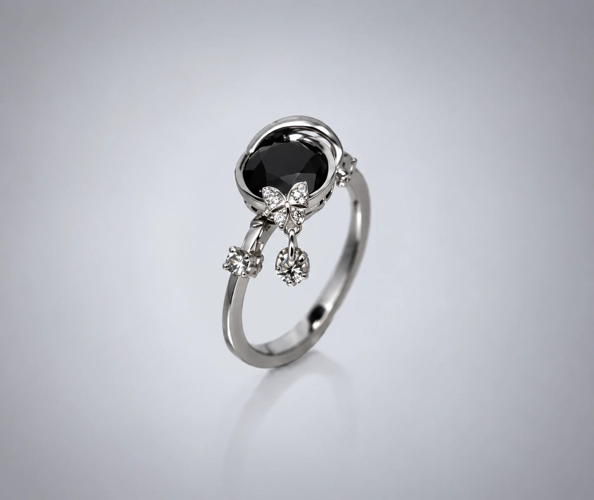 Ring med sort diamant og to lyse, bevægelige detaljer