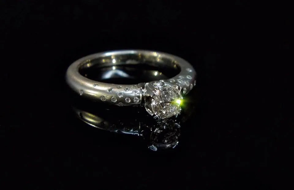 Ring med lys sten og små sidedetaljer
