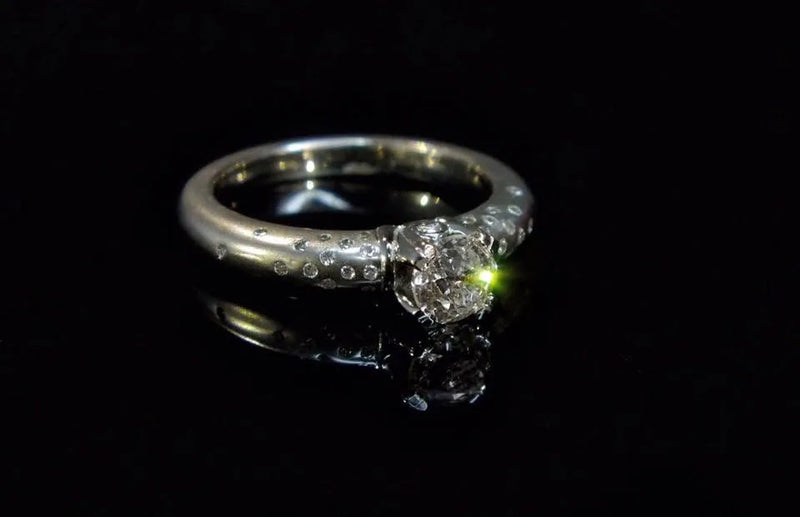 Ring med lys sten og små sidedetaljer