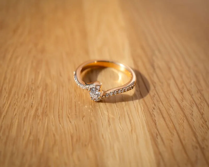 Forlovelsesring i gult guld med svungen diamantbesat form