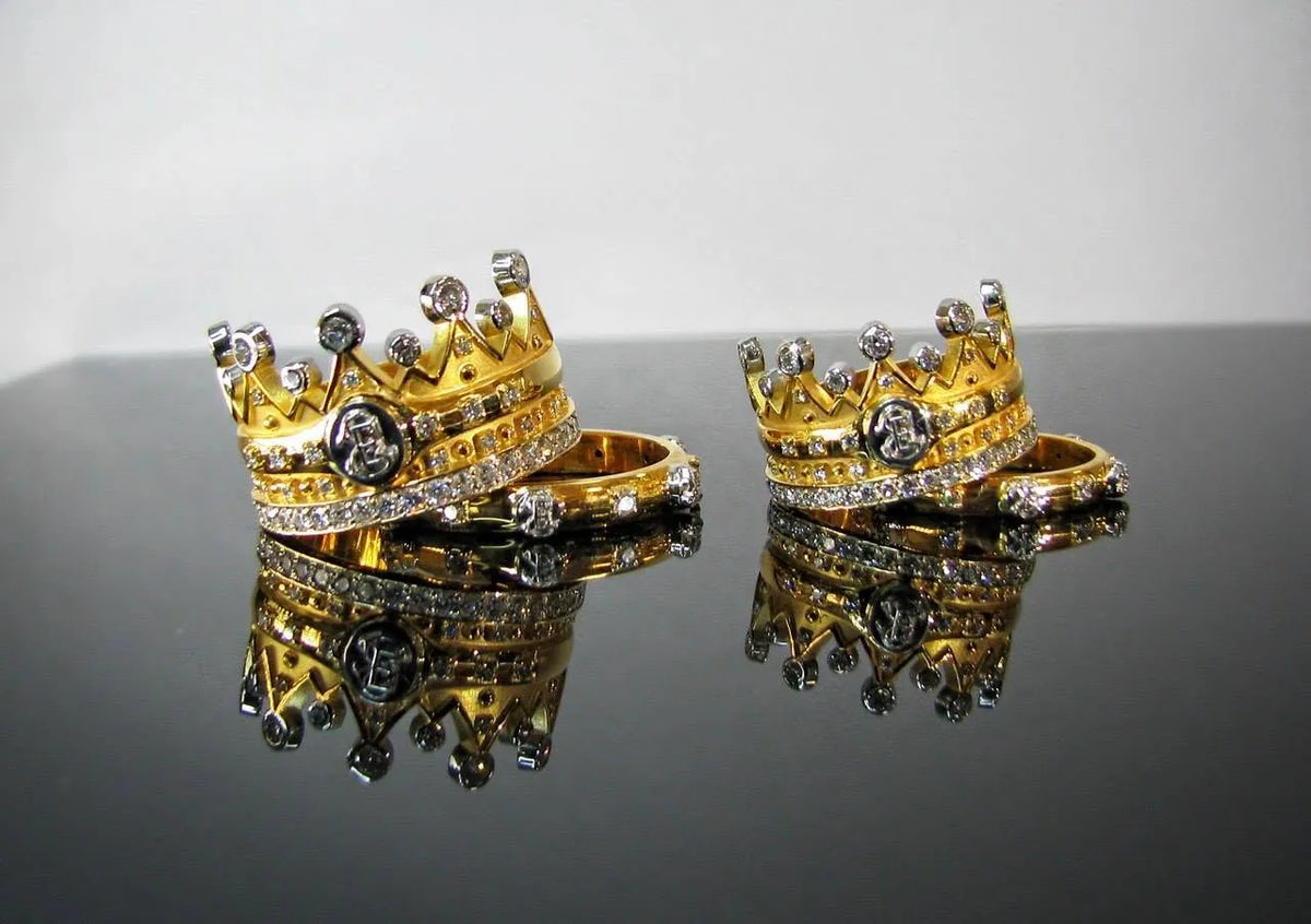 Fire vielsesringe i hvidguld og gult guld, to med kroneform og monogrammer og to med enklere ringform