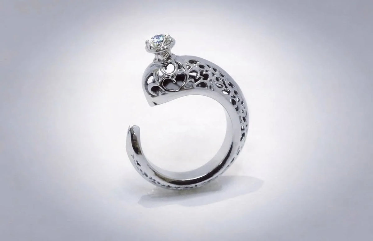 Åben ring med ornamenter og lys sten
