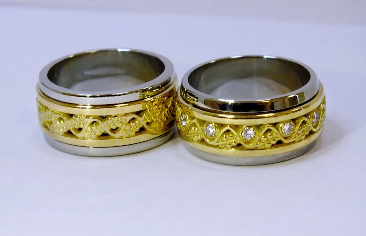 Brede, massive vielsesringe i hvidguld og gult guld med geometrisk mønster og diamanter i hendes ring