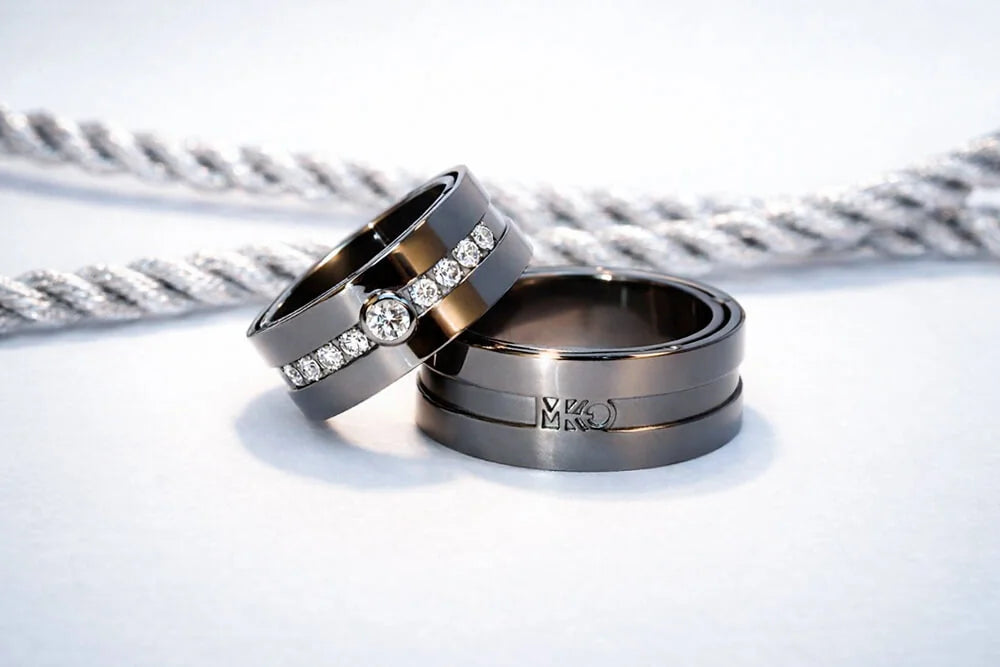 Vielsesringe i hvidguld med sort rhodium, hvide diamanter på hendes ring og en monogramgravering på hans