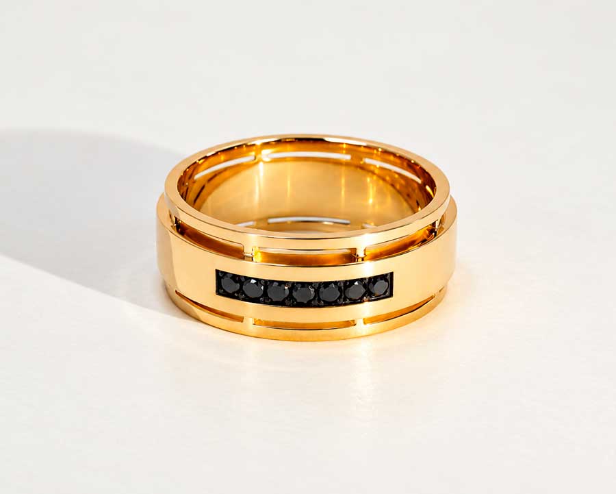 Vielsesringe i gult guld med blanke flader og en række sorte diamanter i den ene ring