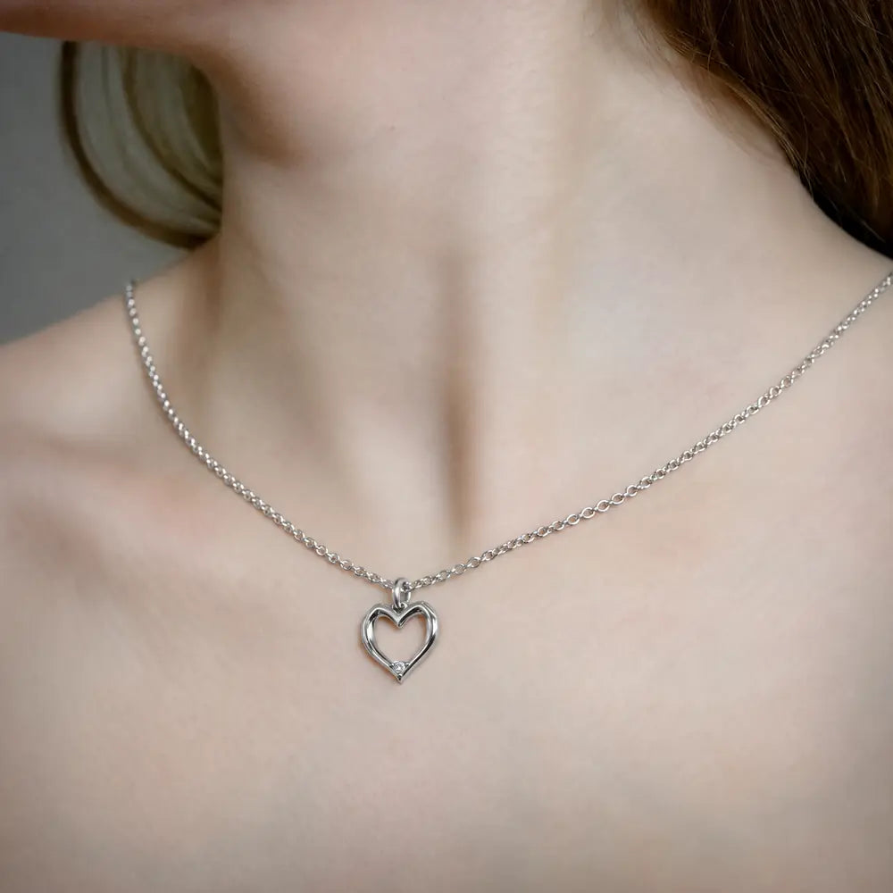 Hjertevedhæng i 18 kt hvidguld med naturlig diamant, båret på halsen