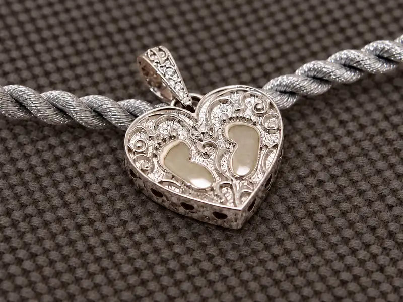 Forsiden med barnets to fodaftryk og diamant i hvidguld.