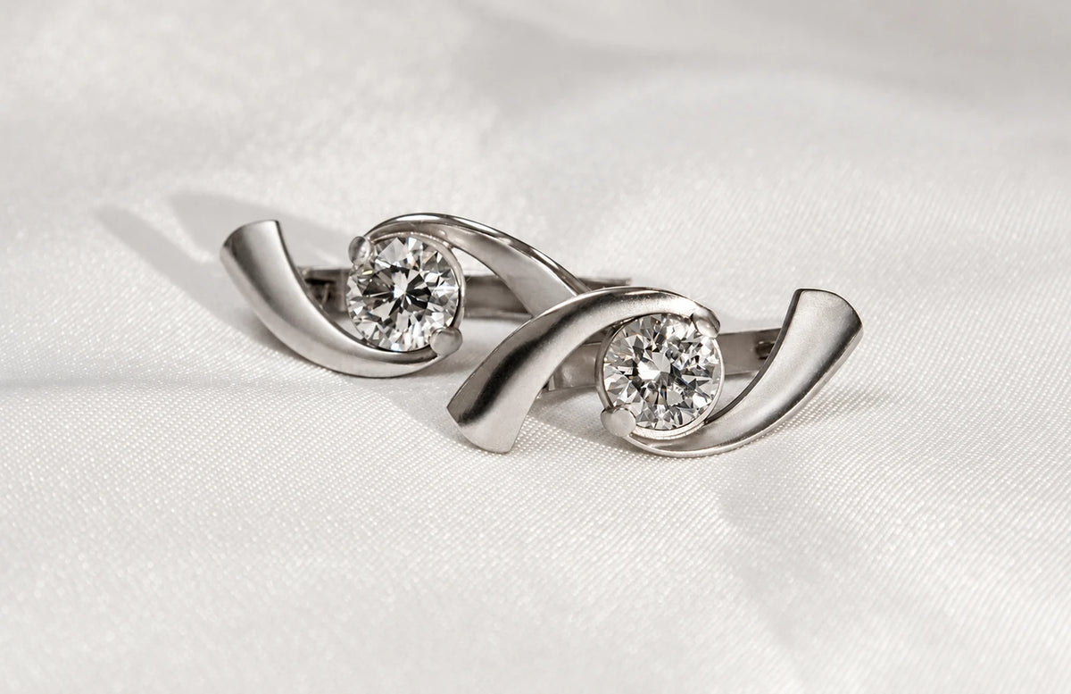 Buede øreringe i hvidguld med en rund diamant på 1 carat i hver ørering